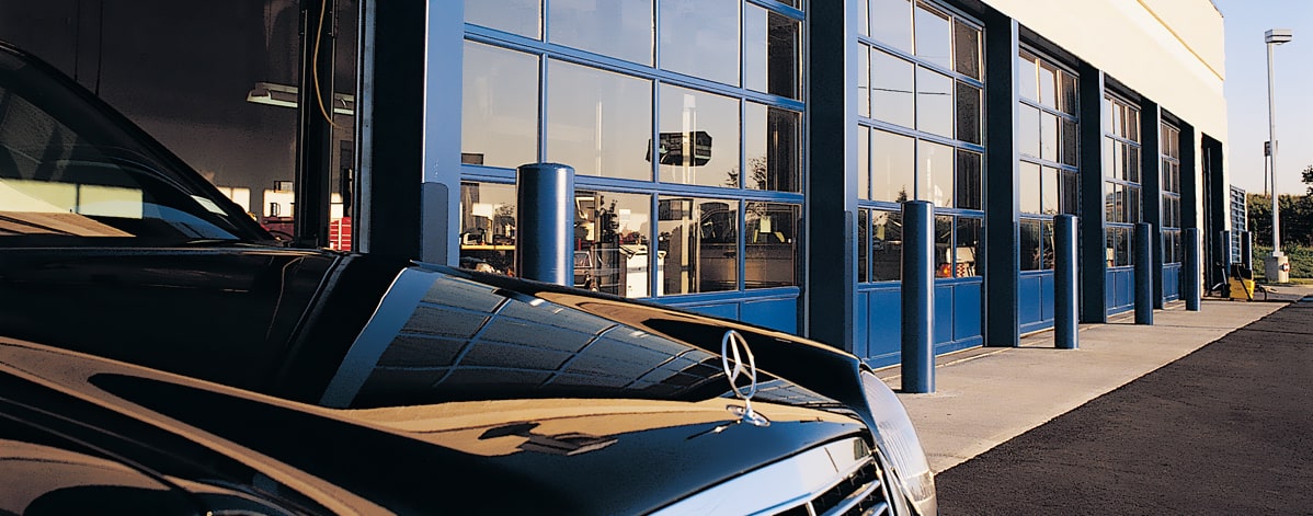 Luxury car in front of several aluminum garage doors